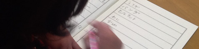 ノートに動物の名前を書いている女の子の写真